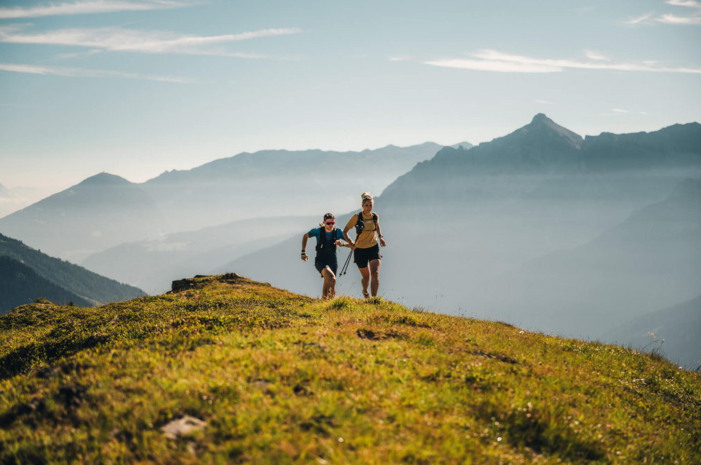 Trailrunner beim Laufen, im Hintergrund eine Bergkulisse