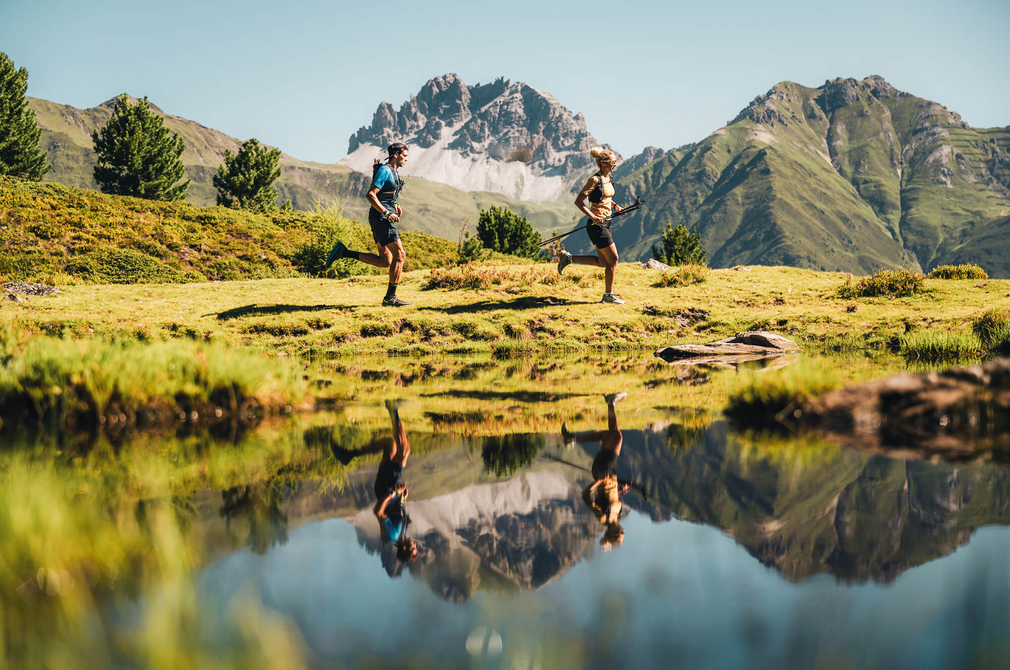 Trailrunner auf der Laufstrecke mit See- und Bergkulisse